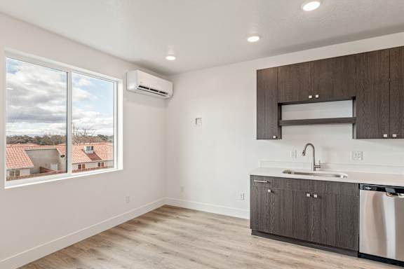 A kitchen with a window overlooking a residential area.