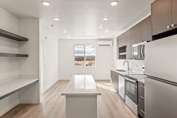 A modern kitchen with a white island in the middle.