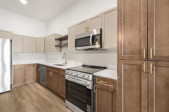 A kitchen with wooden cabinets and a stainless steel refrigerator.