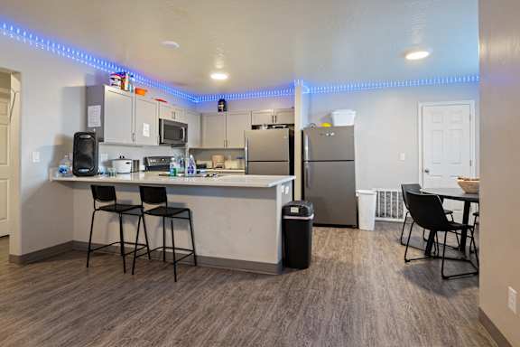 A kitchen with a bar area and a refrigerator.
