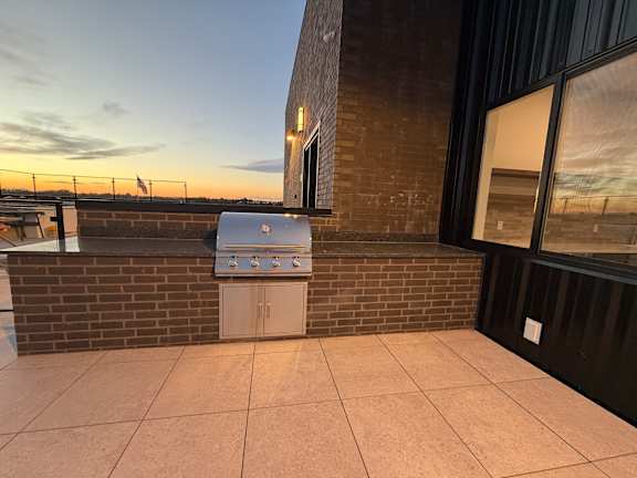 A small white fridge on a patio.