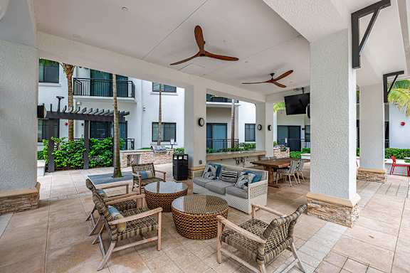 A patio with a table and chairs and a ceiling fan.