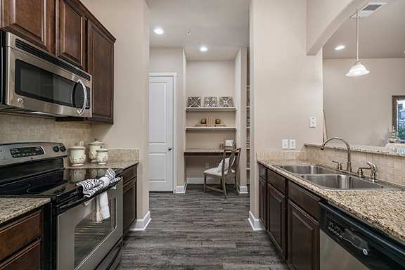 Slab granite kitchen countertops with mosaic backsplash - Monterra Las Colinas Apartments
