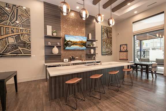 A modern kitchen with a bar area and wooden floors.
