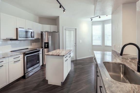 a kitchen with white cabinets and stainless steel appliances