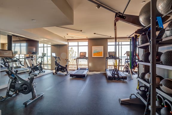 a gym with weights and other exercise equipment and windows