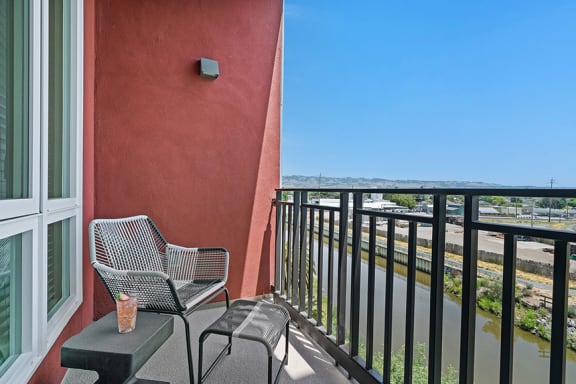a balcony with two chairs and a coffee table