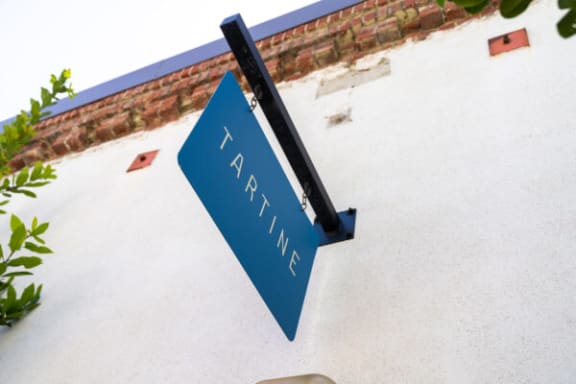 a blue street sign hanging from the side of a building