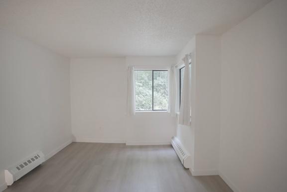 A room with a window and a radiator on the wall.