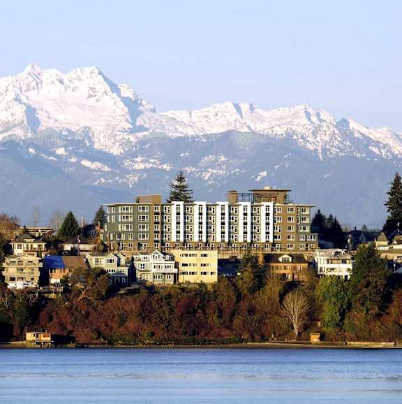 A large building sits in front of a snowy mountain range.