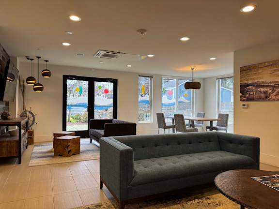 A living room with a grey couch and a wooden table.