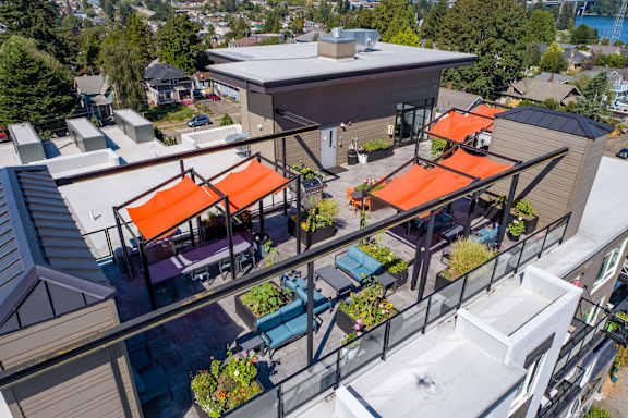 A patio with orange awnings and a glass railing.