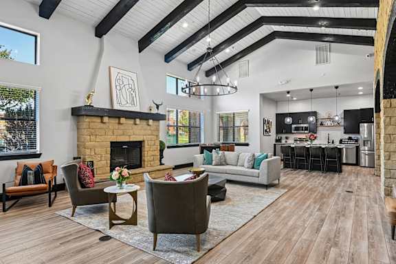 A modern living room with a fireplace and a dining area.