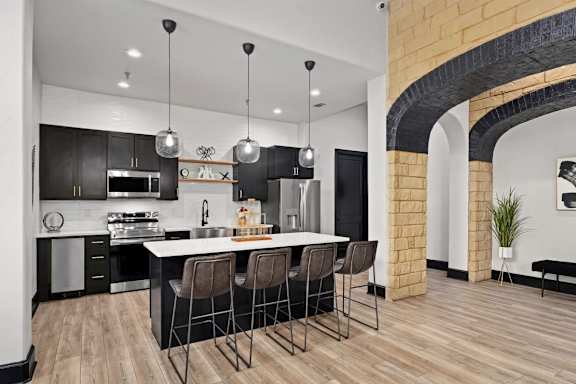 A modern kitchen with a large island and bar stools.