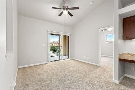 A room with a ceiling fan and carpeted floor.