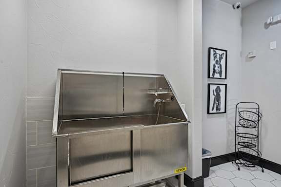 A large stainless steel box with a door and a handle is on a tiled floor.