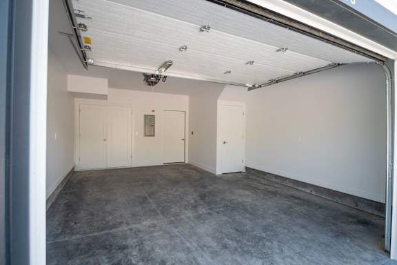A large empty room with white walls and a concrete floor.
