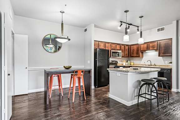 A kitchen with a table and chairs and a fridge.