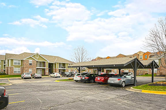 A parking lot with cars and apartment buildings in the background.