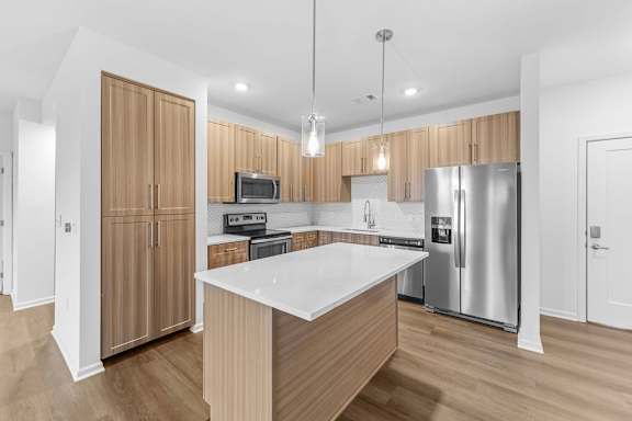 A modern kitchen with wooden cabinets and stainless steel appliances.