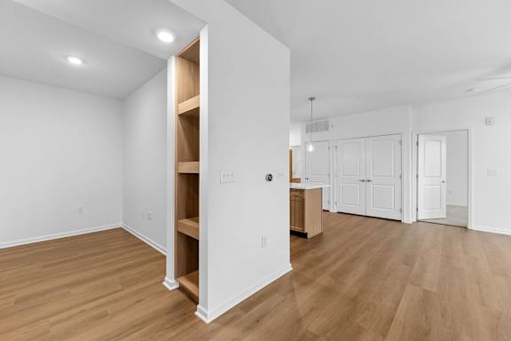 A room with a white wall and a wooden floor.