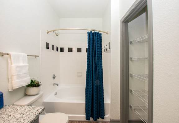 A small bathroom with a blue shower curtain.