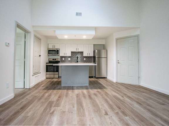 A kitchen with a wooden floor and white walls.