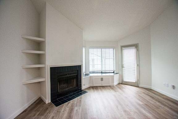 A living room with a fireplace and a window.