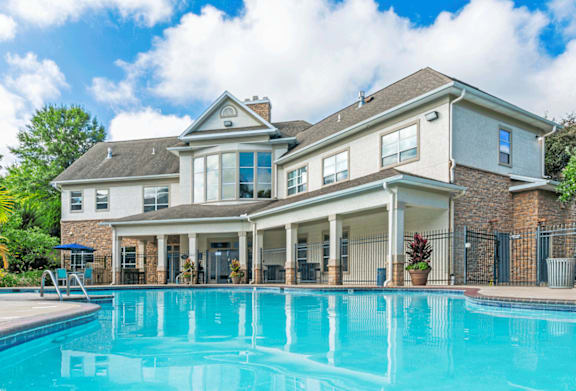 A large house with a swimming pool in front.