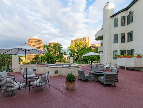 A patio with chairs and tables overlooking a city skyline.