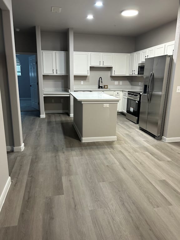 A kitchen with a refrigerator, oven, and cabinets.