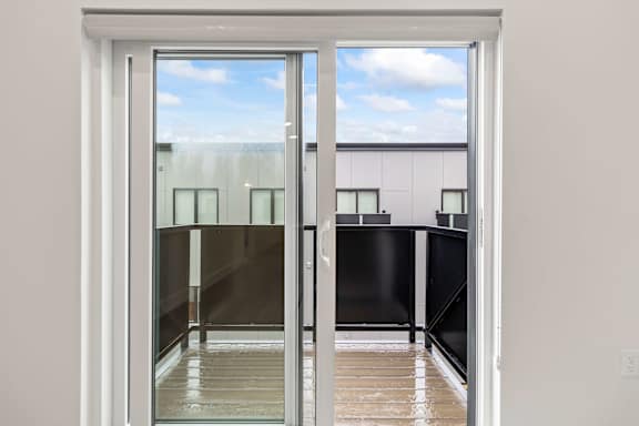 A view of a balcony through a sliding glass door.