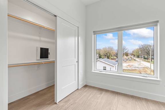 A room with a sliding door and a window showing a view of a street.