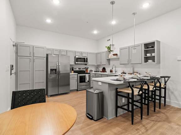 A kitchen with a table and chairs and a fridge.