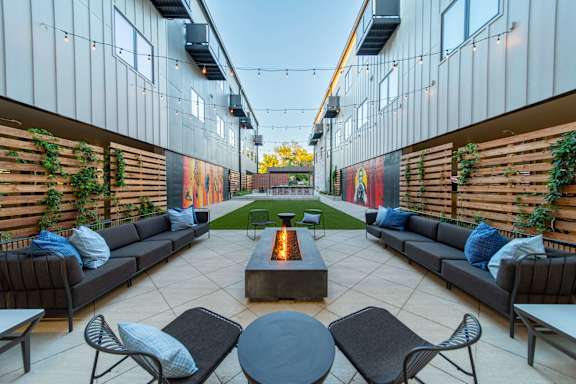 A patio with a fire pit and seating area.
