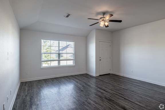 A room with a ceiling fan and a window with blinds.