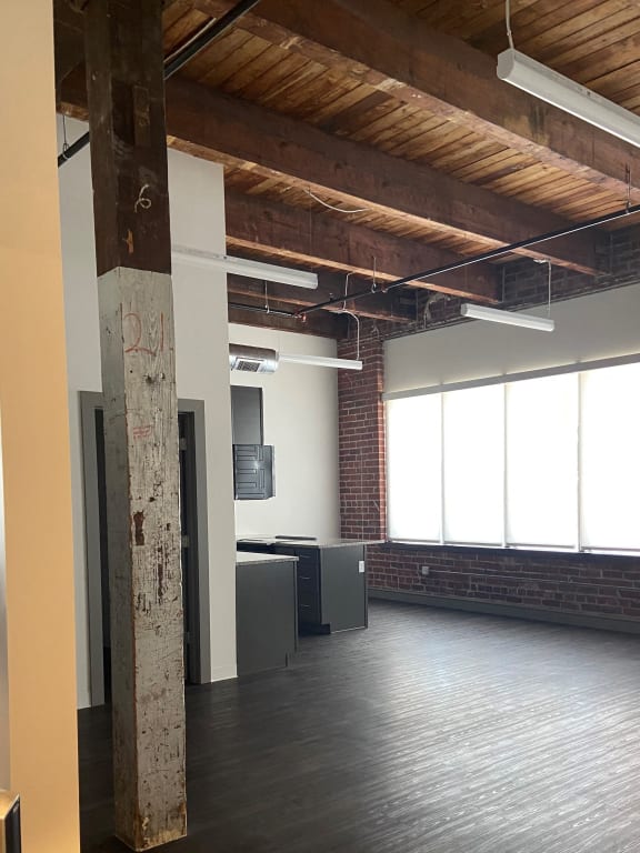 an empty room with a brick wall and wood floors