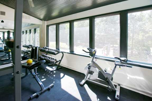 A gym with a rowing machine and a dumbbell.