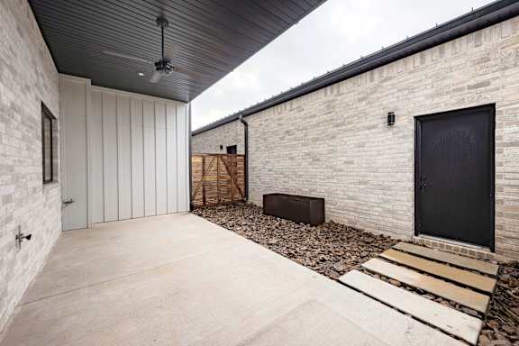 A modern house with a black door and a black ceiling fan.