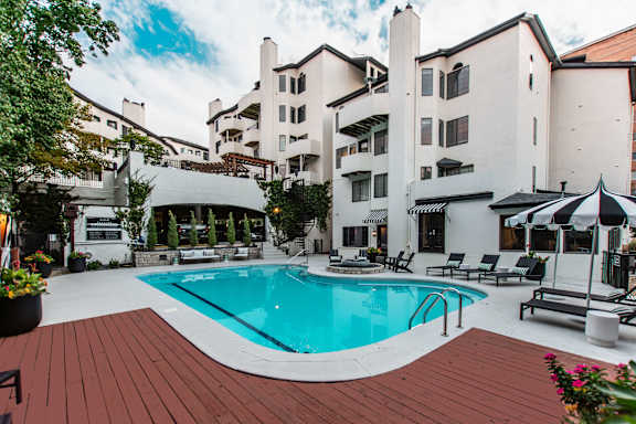 A large white building with a pool in front.
