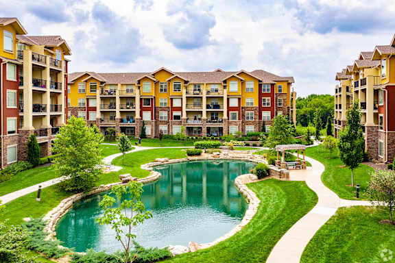 A large building with a pool in front of it.