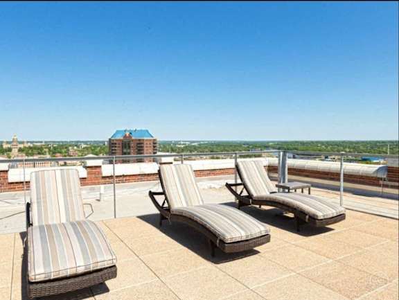 Three striped sun loungers on a patio.