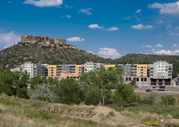 A mountain with a few buildings in front of it.
