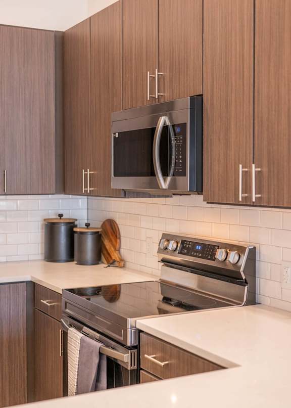 A modern kitchen with a stainless steel oven and microwave.