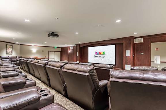 A conference room with brown leather chairs and a Connect555 screen.