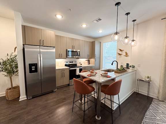 A modern kitchen with a dining table set for two.
