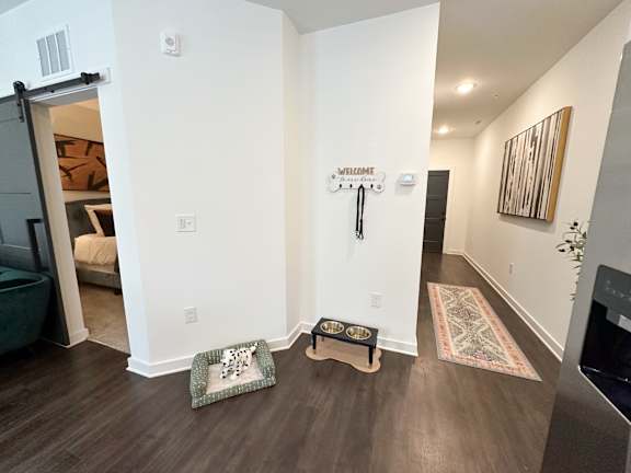 A hallway with a welcome sign and a rug on the floor.