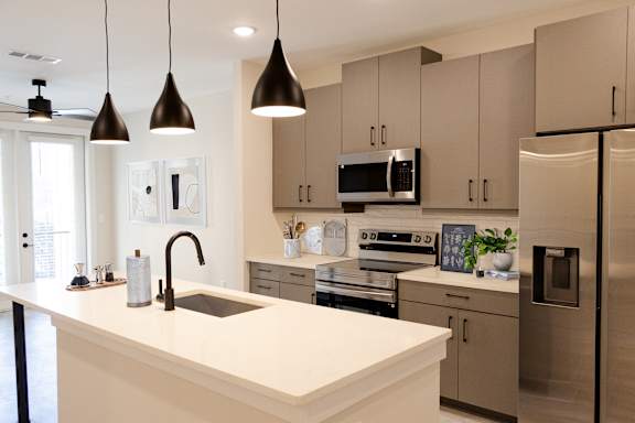 A modern kitchen with a white countertop and stainless steel appliances.at Riverside Apartments, Tennessee, 37406
