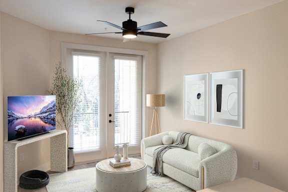 A living room with a television, a couch, and a fan.at Riverside Apartments, Chattanooga, TN