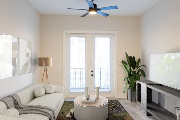 A living room with a white sofa, a round coffee table, and a ceiling fan.at Riverside Apartments, Chattanooga, TN